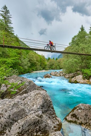 Foto de Agradable mujer en un recorrido en bicicleta a lo largo del río Soca con su bicicleta de montaña eléctrica en el Parque Nacional Triglav en Eslovenia - Imagen libre de derechos