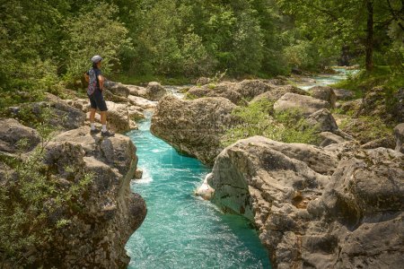 woman resting during a hiking tour along turquoise River Soca in the Triglav National Park of the Julian Alps in Slovenia