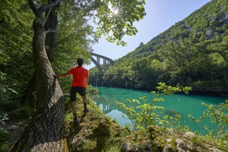 Téléchargez les photos : Femme au repos lors d'une randonnée le long de la rivière turquoise Soca dans le parc national du Triglav des Alpes juliennes en Slovénie - en image libre de droit