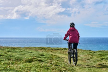 Foto de Agradable mujer mayor en bicicleta de montaña, ciclismo en los acantilados de Cnoc an Daimh, Kilgalligan la parte norte de la República de Irlanda - Imagen libre de derechos