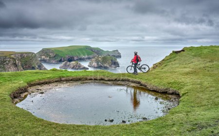 Foto de Agradable mujer mayor en bicicleta de montaña, ciclismo en los acantilados de Malin Beg Head, Donegal, norte de la República de Irlanda - Imagen libre de derechos