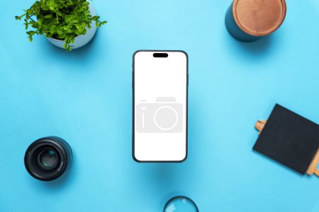 Photo for Phone mockup above a desk with objects around. Levitation above top view, flat lay composition. Isolated display for mockup, app user interface presentation - Royalty Free Image