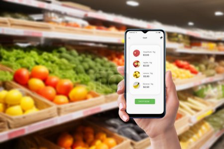 Smartphone used in grocery store displaying purchased items and prices. Efficient shopping app for tracking groceries and expenses