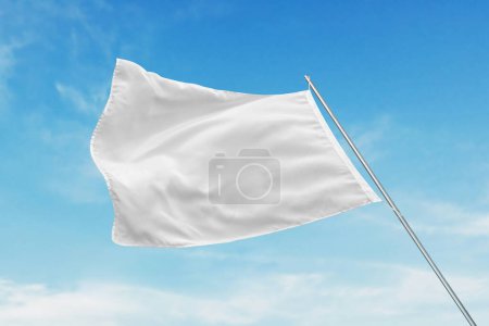 Una bandera blanca ondea en el viento con textura limpia, perfecta para maqueta de bandera estatal o publicitaria, colocada contra un cielo azul claro