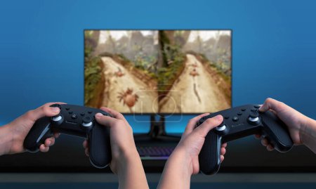 Two players using gamepads, playing a game on a computer with a split-screen display. Great for showcasing multiplayer gaming experiences