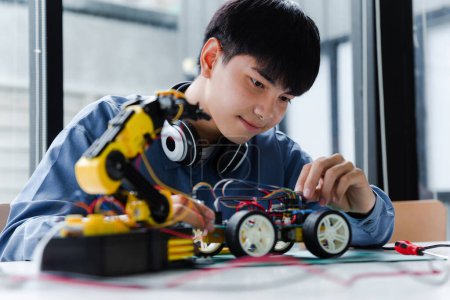Asiatischer Teenager beim Roboterprojekt im naturwissenschaftlichen Unterricht. Technologie der Robotik-Programmierung und MINT-Ausbildungskonzept.