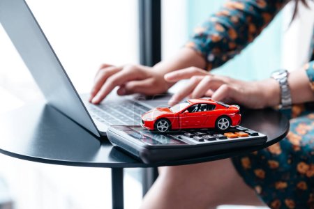 car finance and insurance concept. Young woman selling or buying car online.