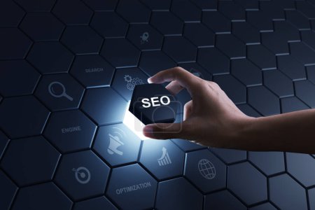 Hand of human putting hexagon piece to full fill the part of SEO Search Engine Optimization