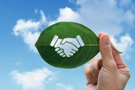 Photo for Hand of human is holding green leaf with handshake icon, environment social and governance or ESG - Royalty Free Image