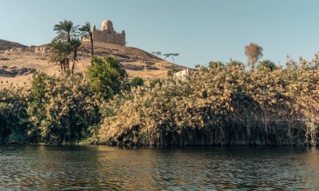 Téléchargez les photos : Paysage de l'oasis de la rive du Nil avec Mausolée d'Aga Khan n arrière-plan, Voyage Egypte Croisière sur le Nil - en image libre de droit