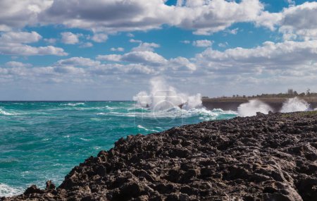 Big waves crashing against the volcanic lava rocks of a sea shore.