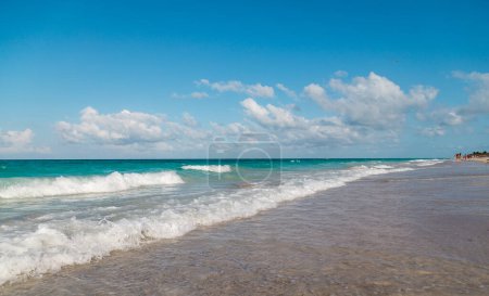 Turquoise blue Atlantic waves and blue sky with white clouds on Varadero beach.