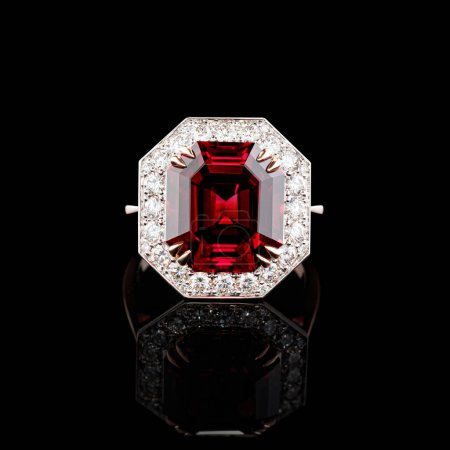 Téléchargez les photos : Belle bague en or rouge avec diamants et grenat sur fond noir close-up - en image libre de droit