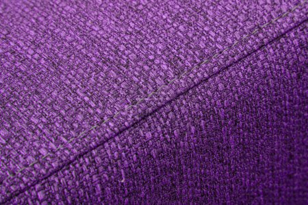 Textured violet furniture fabric with stitching close-up