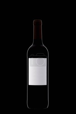 Photo for Bottle of wine with a white label with beautiful highlights on a black background close-up - Royalty Free Image