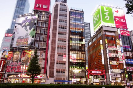Téléchargez les photos : Shinjuku, Tokyo, Japon - 03 août 2023 : Des gens marchent dans la célèbre sortie Est de Shinjuku, Kabukicho, les illuminations au néon et le quartier animé des divertissements de Tokyo. - en image libre de droit