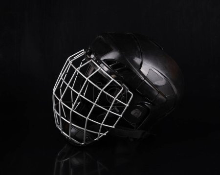 casco de hockey protector negro aislado sobre fondo negro