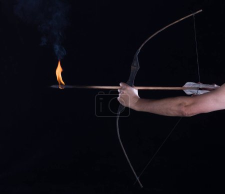 Téléchargez les photos : Archer tire une flèche flamboyante d'un arc - en image libre de droit