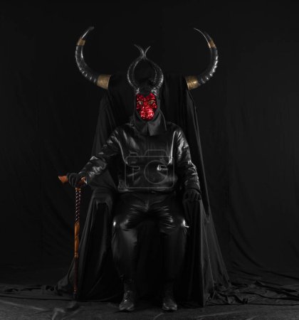 Photo for Portrait of a male devil with horns on a black throne - Royalty Free Image