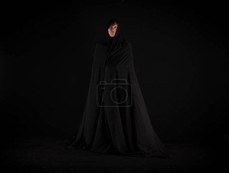 Téléchargez les photos : Moine en robe noire sur fond noir - en image libre de droit