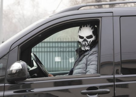 der Verbrecher in der Maske im Auto