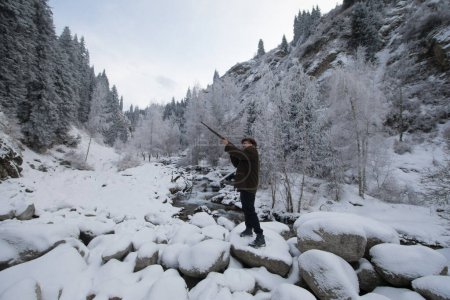 Foto de Cazador vintage con un arma en el bosque de invierno - Imagen libre de derechos