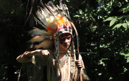 Indian Apache girl with a bow in the forest
