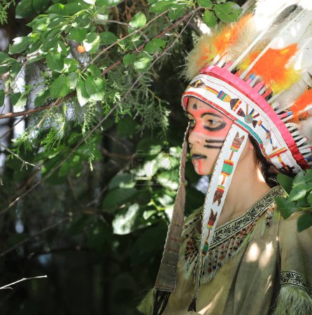 Indian Apache girl with a bow in the forest