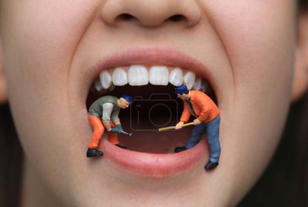 Kleine Figur Arbeiter putzt Zahnmodell