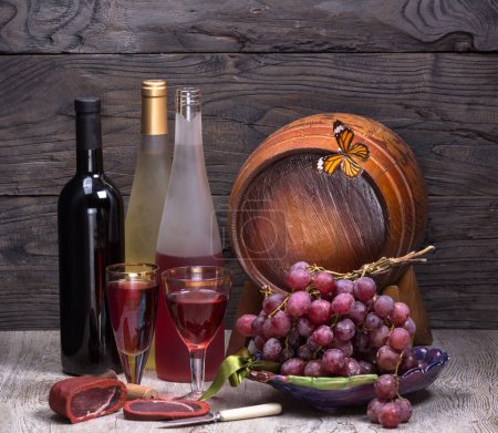 Photo for Bottle of wine and wooden barrel for wine on a wooden table, still life, wine tavern - Royalty Free Image