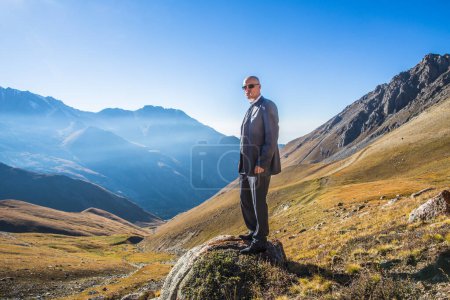 Téléchargez les photos : Homme en costume sur fond de montagnes en été, panorama, paysage, homme d'affaires - en image libre de droit