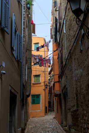 Photo for Old town alley in the Croatian town of Rovinj with old residential building fronts and freely laid power cables - Royalty Free Image