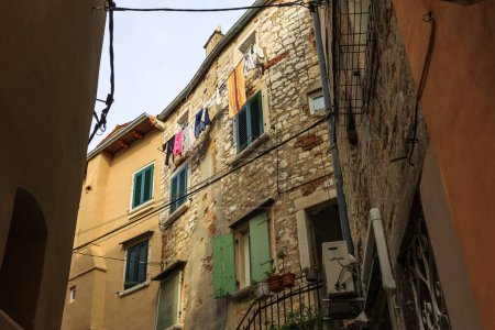 Téléchargez les photos : Ruelle de la vieille ville dans la ville croate de Rovinj avec façades de vieux bâtiments résidentiels et câbles d'alimentation librement posés - en image libre de droit
