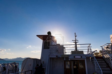 Téléchargez les photos : Cheminée et radeau de sauvetage sur le ferry pour l'île d'Elbe en Toscane dans le rétroéclairage - en image libre de droit