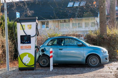 Foto de Germany, Dieen, 06.01.2023, A blue Fiat 500 electric convertible with black roof is charging at a Energie South bavaria charging station - Imagen libre de derechos