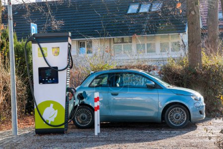 Photo for Germany, Dieen, 06.01.2023, A blue Fiat 500 electric convertible with black roof is charging at a charging station - Royalty Free Image