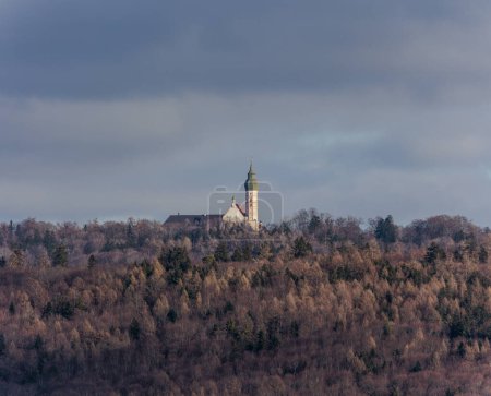Téléchargez les photos : At the Ammersee the towers of Andechs monastery stand between wintry woods and the cloudy sky - en image libre de droit