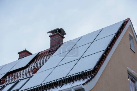 Foto de Los módulos fotovoltaicos cubiertos de nieve en el techo de una casa no suministran electricidad - Imagen libre de derechos
