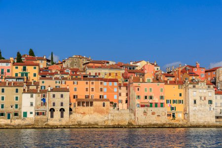 Foto de The old town of Rovinj with the church of St. Euphemia seen from the sea on a sunny day with blue sky - Imagen libre de derechos