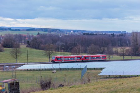 Foto de Parque solar en un entorno rural frente a una línea de ferrocarril en Gaishaus cerca de Ravensburg en Baden Wrtemberg en un día nublado en invierno. - Imagen libre de derechos