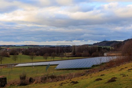 Foto de Parque solar en un entorno rural frente a una línea de ferrocarril en Gaishaus cerca de Ravensburg en Baden Wrtemberg en un día nublado en invierno. - Imagen libre de derechos