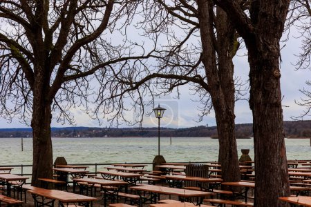 Foto de Un jardín de cerveza vacío en las vacaciones de invierno en un día lluvioso ventoso con cielo nublado en Stegen am Ammersee - Imagen libre de derechos