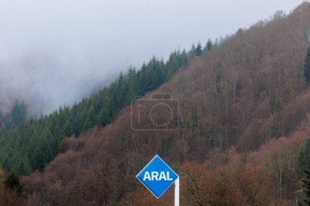 Téléchargez les photos : Todtnau, Allemagne, 2.4.2023, panneau publicitaire d'une station-service ARAL devant des bois brumeux - en image libre de droit