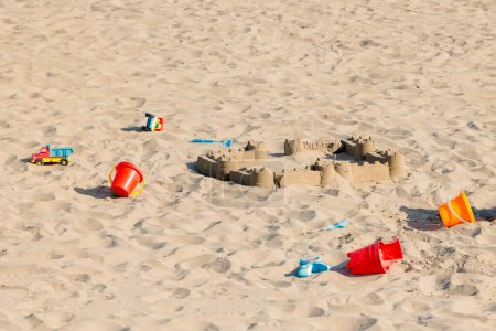 Foto de Castillo de arena abandonado con juguetes infantiles en la playa de arena de Santa María de la Mer - Imagen libre de derechos