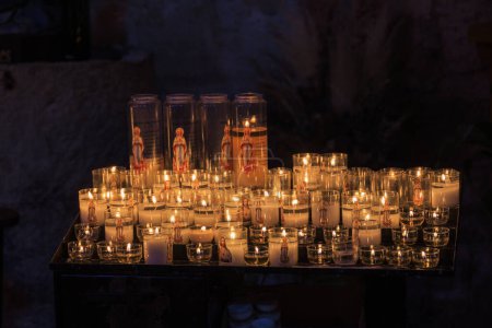 Téléchargez les photos : Diverses bougies avec des images religieuses chrétiennes dans la vieille ville d'Aigues-Mortes à Camarque - en image libre de droit