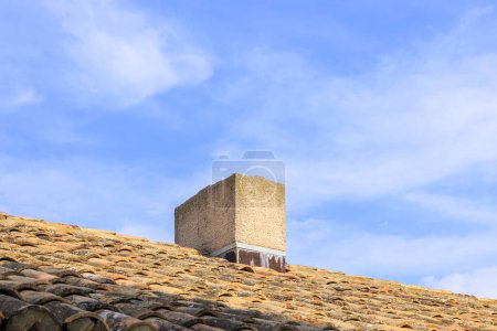Foto de An old brick chimney on a tiled roof against a blue sky in Aigues-Mortes in France - Imagen libre de derechos