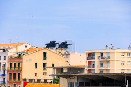Téléchargez les photos : Un énorme bateau de croisière dans le port de la ville française de Sète domine les bâtiments résidentiels de la ville - en image libre de droit
