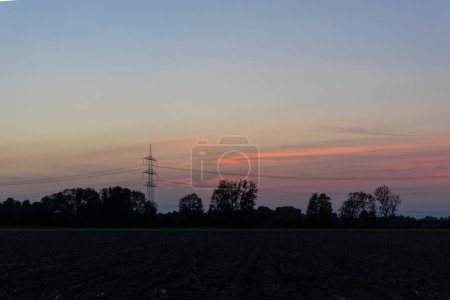 Téléchargez les photos : Poteau électrique avec lignes électriques le soir au coucher du soleil sur les champs près de Mering au lac Mandicho - en image libre de droit