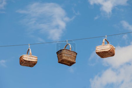 Photo for Wicker baskets stretched on ropes in front of blue sky as decoration in the basket weaving town of Lichtenfels in Upper Franconia on the Main River - Royalty Free Image