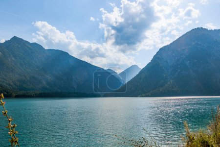 Photo for Evening sun rays through clouds on blue sky over Plansee lake in Austria - Royalty Free Image